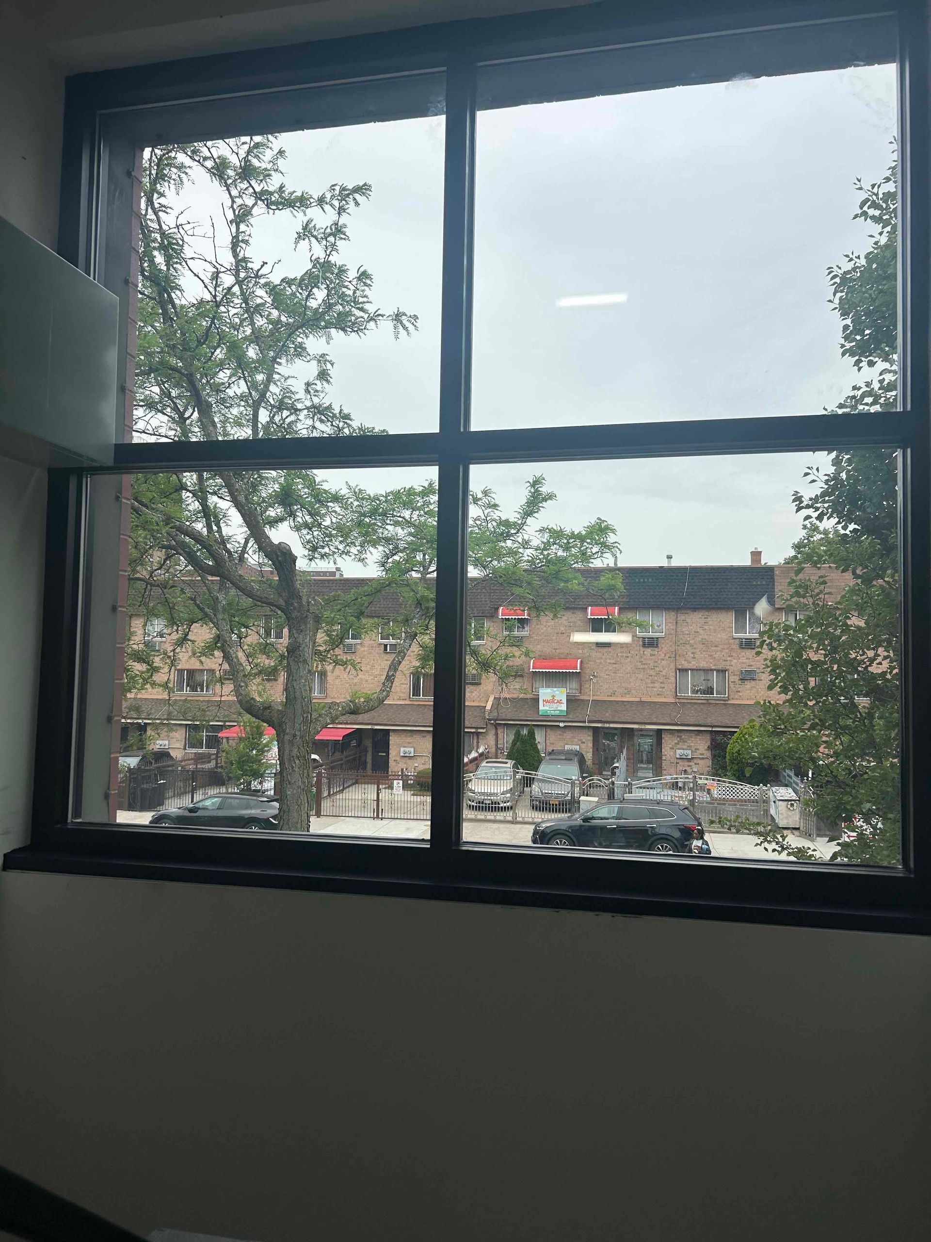 Parker Custom Security crew installing an energy-efficient window in the stairwell of a Bronx apartment building