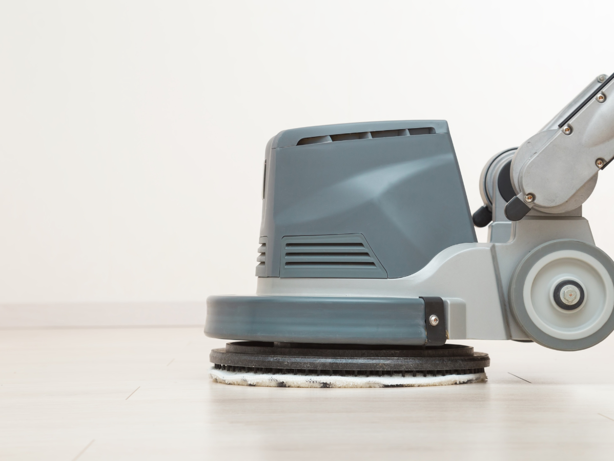 Floor buffer machine polishing a light wood floor