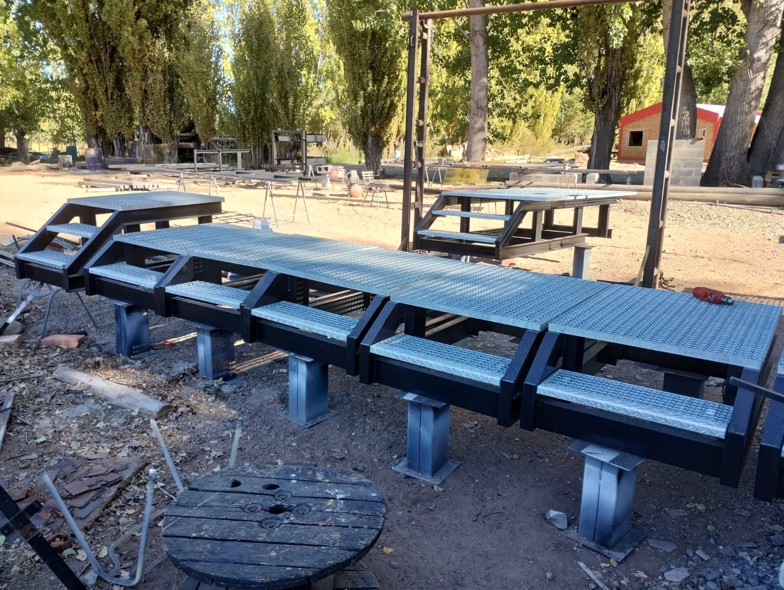 Una fila de escaleras de metal colocadas encima de un campo de tierra.