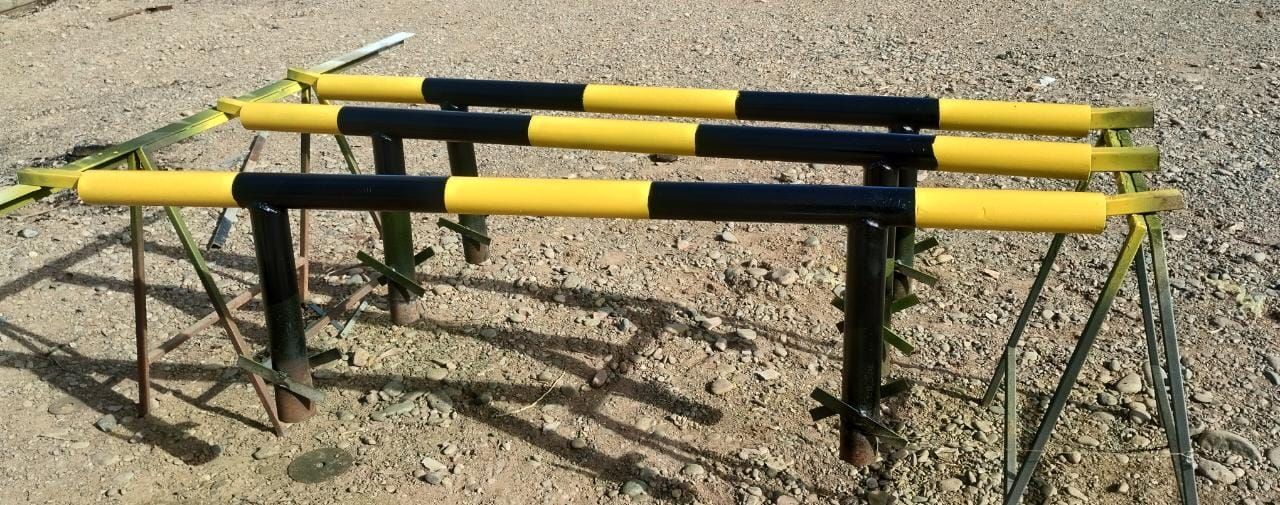 Un obstáculo amarillo y negro se encuentra en un camino de grava.