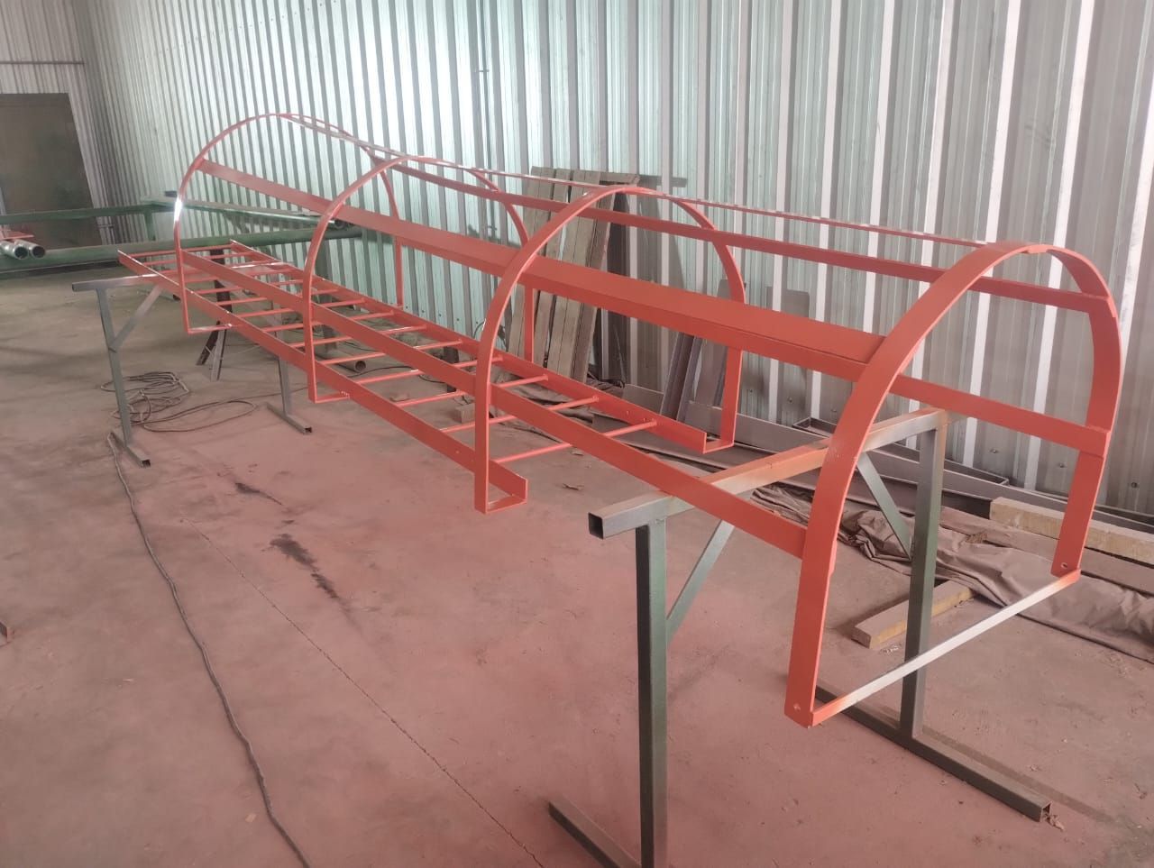 Una estructura de metal rojo está colocada encima de una mesa de madera en una habitación.