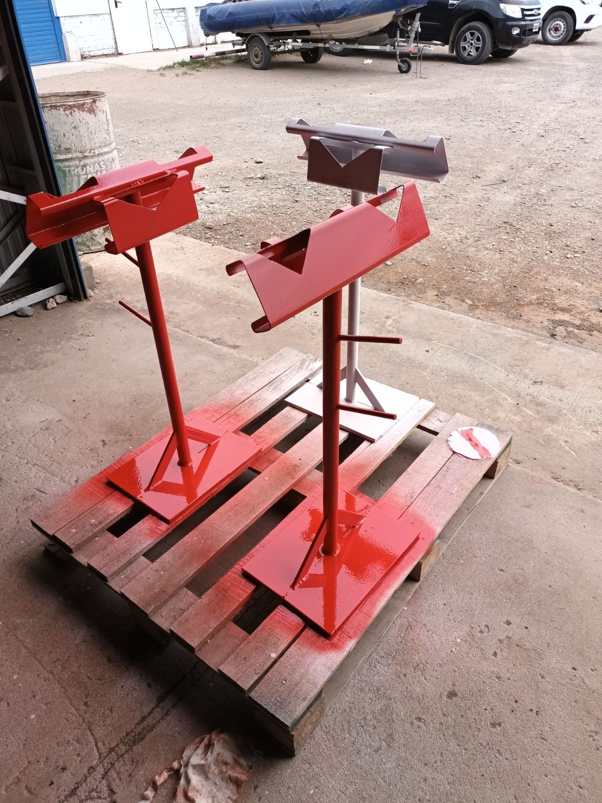 Dos soportes rojos están pintados de rojo sobre una paleta de madera.