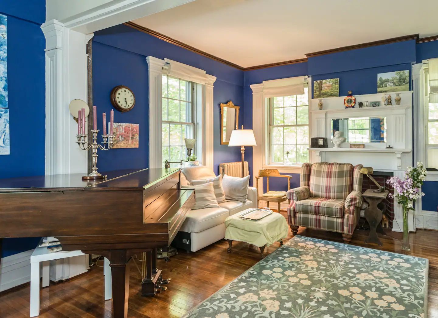 A living room with blue walls and a piano.