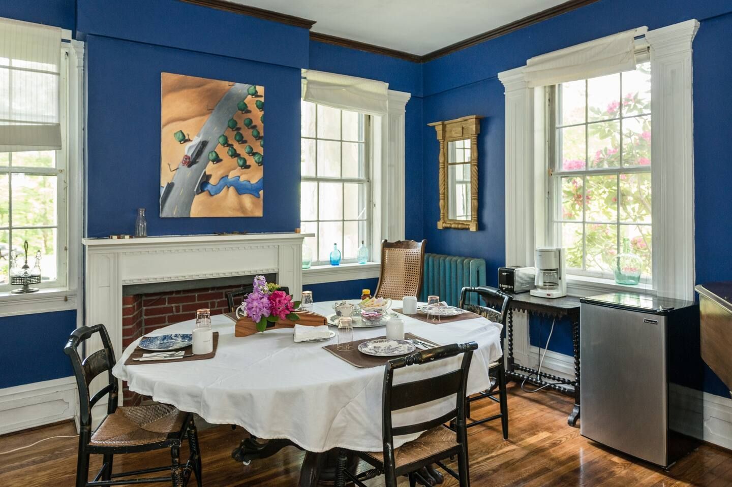 A dining room with a table and chairs and a fireplace.