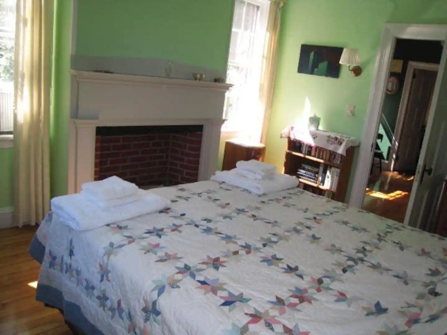 A bedroom with a large bed and a fireplace