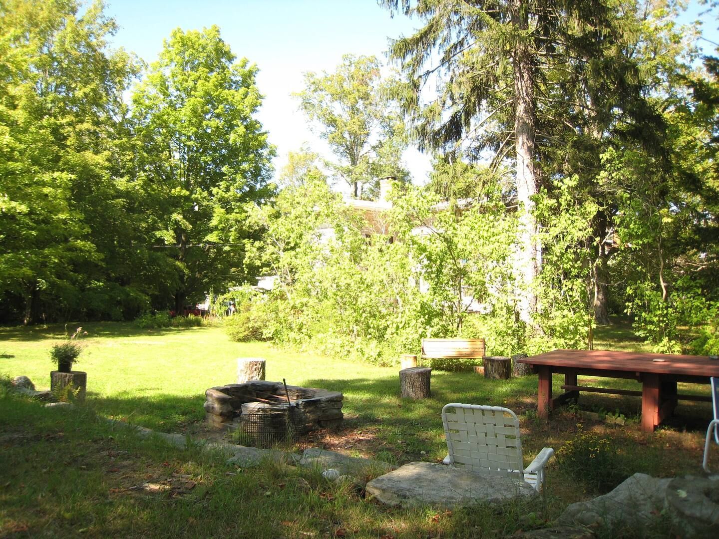 A backyard with a fire pit and a picnic table