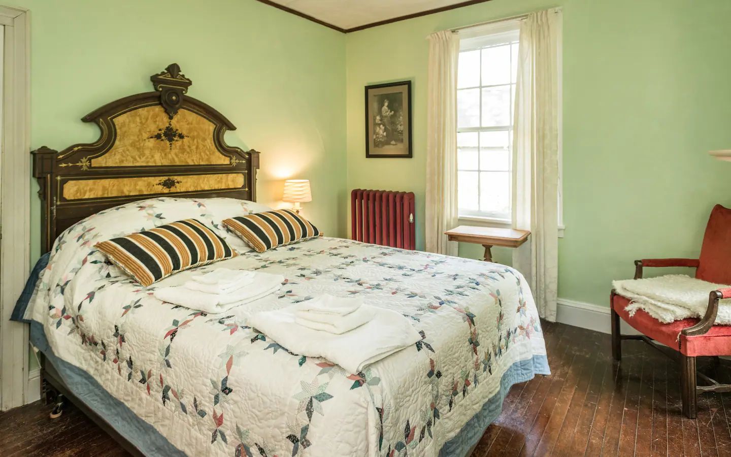 A bedroom with a bed , chair , table and window.