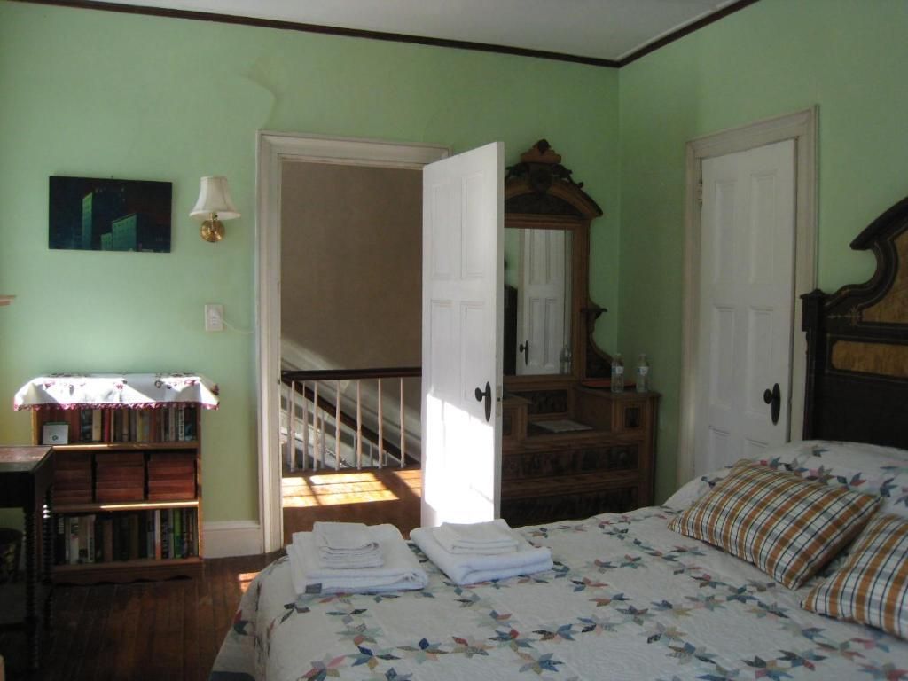 A bedroom with a bed dresser and mirror