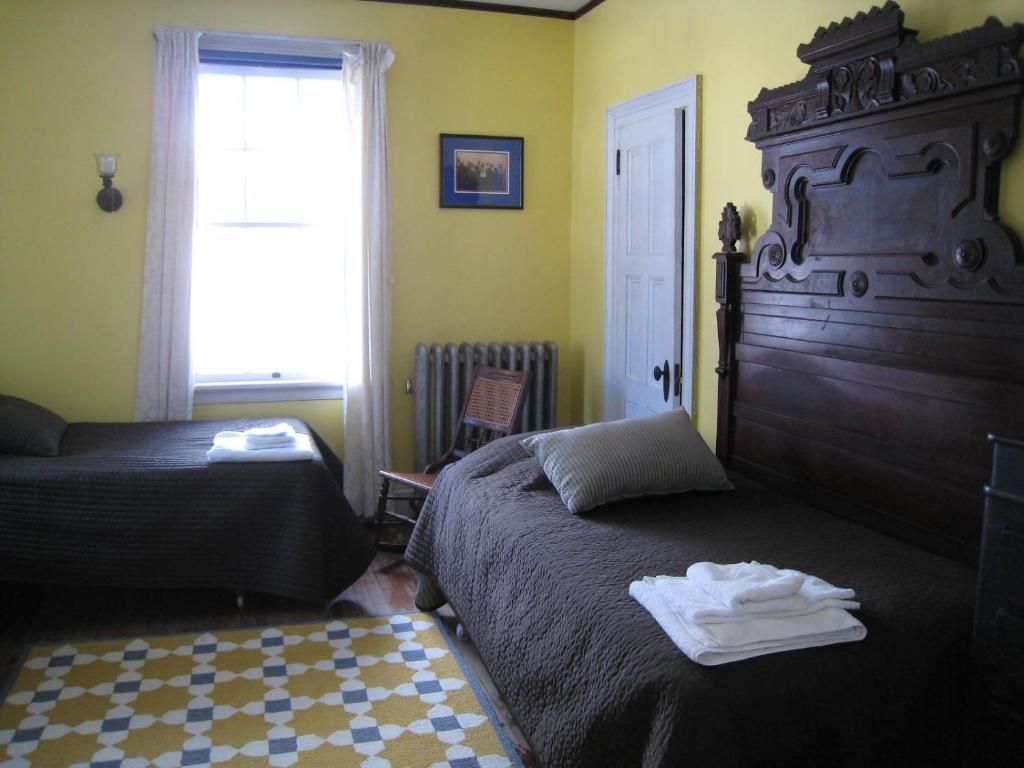 A bedroom with two beds and a picture on the wall