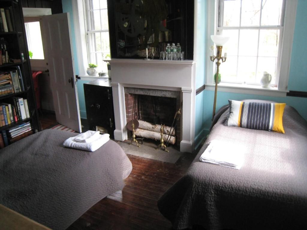 A bedroom with two beds and a fireplace