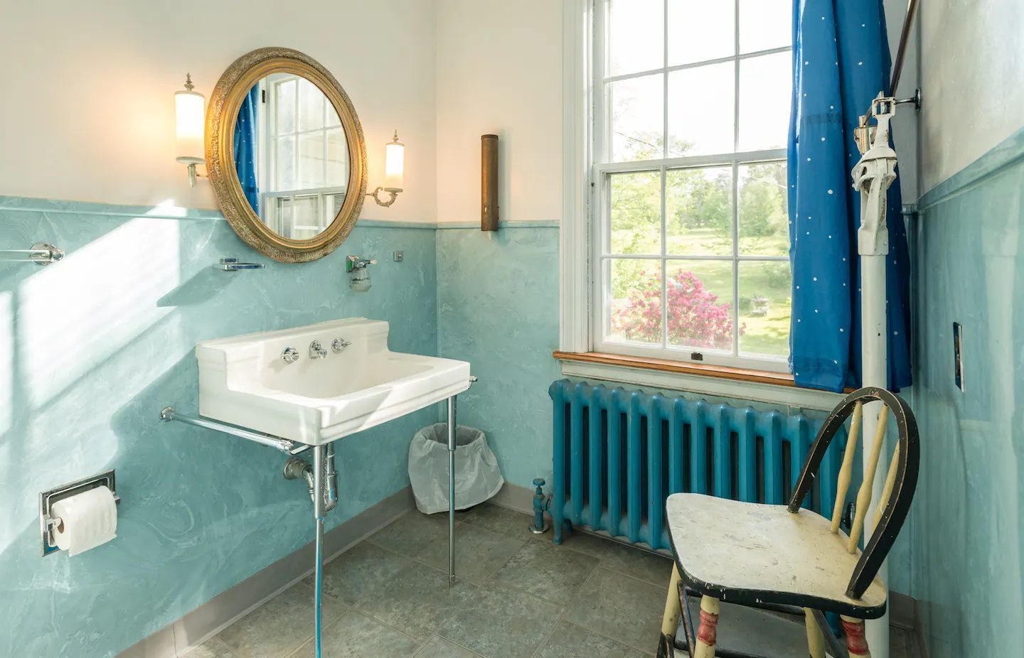 A bathroom with a sink and a chair and a window