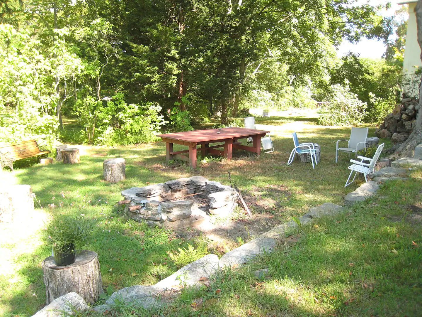 A fire pit in the middle of a lush green field