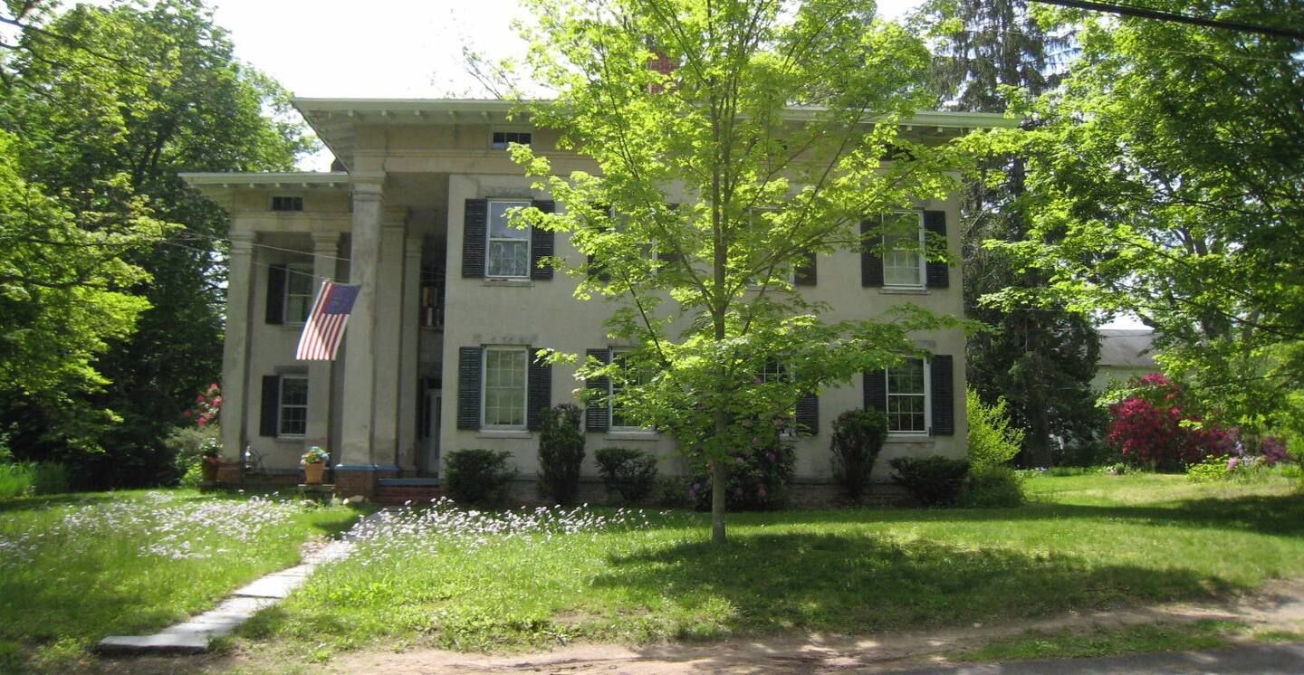 A large white house with a flag in front of it
