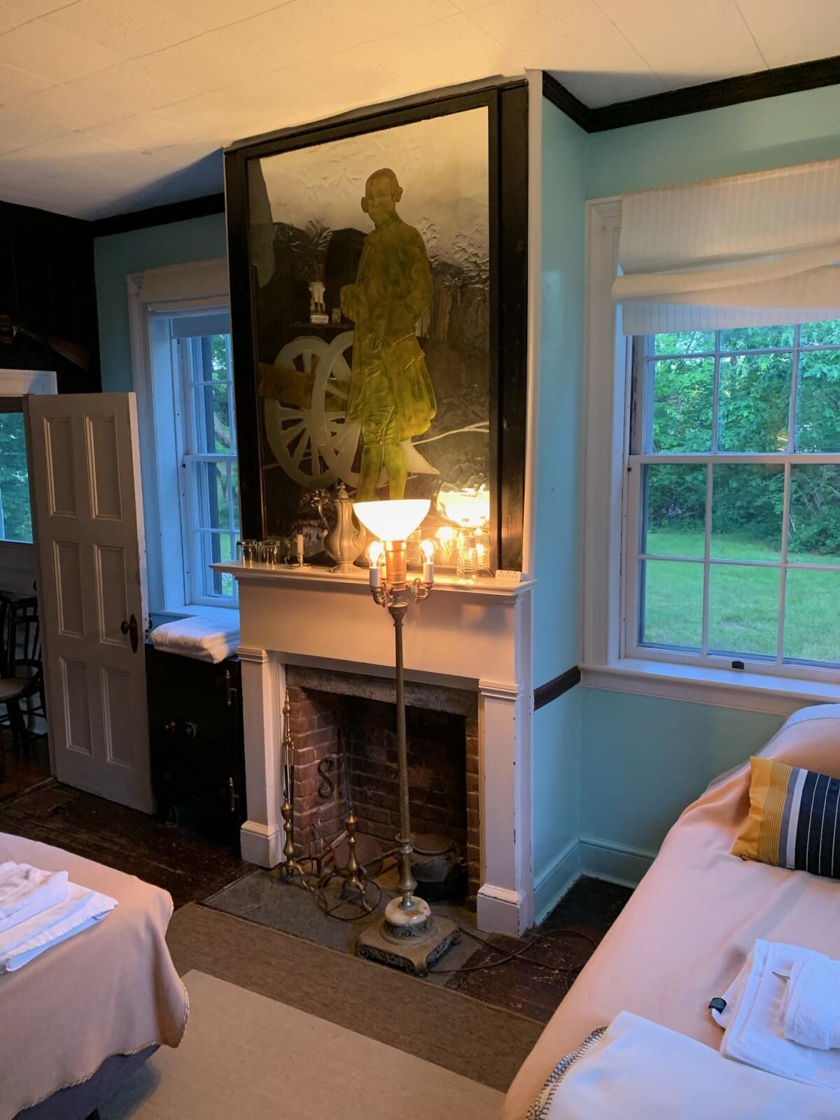 A living room with a fireplace and a painting on the wall.