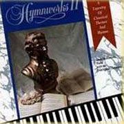 A statue of a man is sitting on top of an open book next to a piano keyboard.