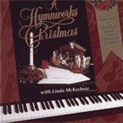 A hymnworks christmas cd is sitting on top of a piano keyboard.