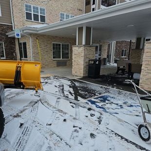 A snow plow is parked in front of a building