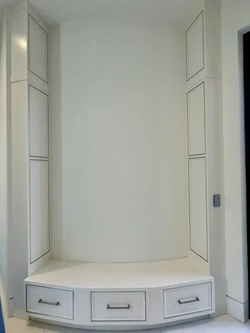 Custom white built-in cabinetry with angled bench seat and inset panel doors in Coconut Creek Florida home.