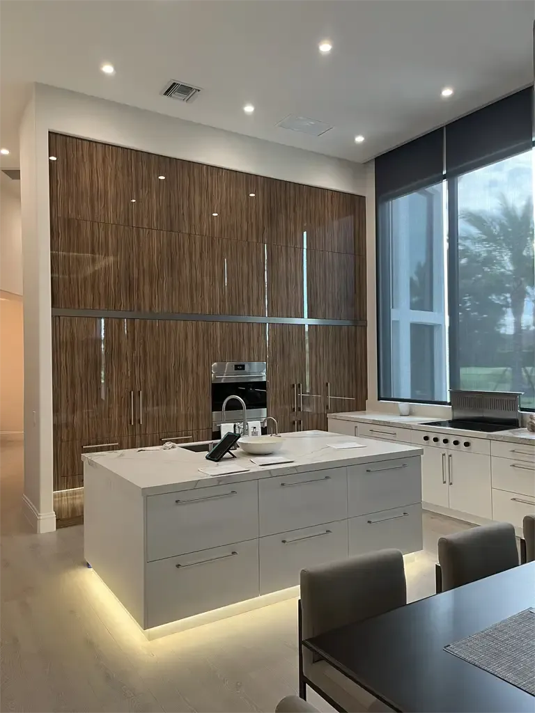 Modern gloss wood cabinets and white island by Kitchen & Bath Studios Inc