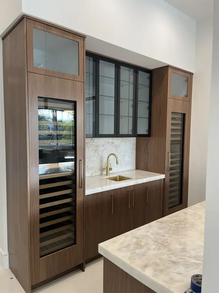 Custom wood wet bar with dual wine storage by Kitchen & Bath Studios Inc