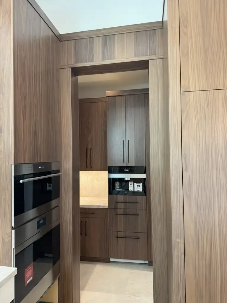 Custom walnut kitchen cabinetry with built-in coffee station by Kitchen & Bath Studios Inc.