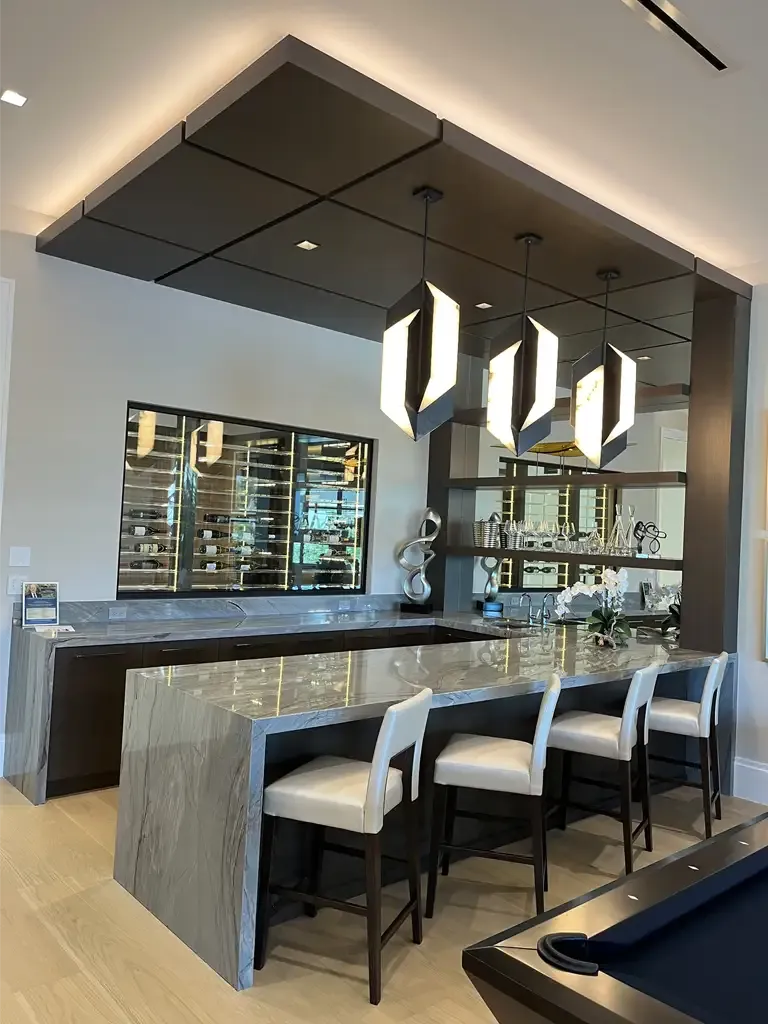 Modern home wet bar with waterfall island and wine wall by Kitchen & Bath Studios Inc