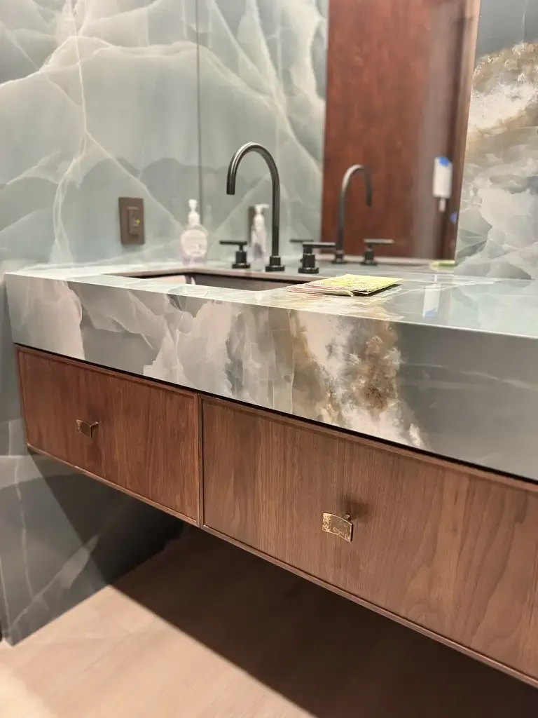 Onyx vanity with walnut cabinets by Kitchen & Bath Studios Inc.