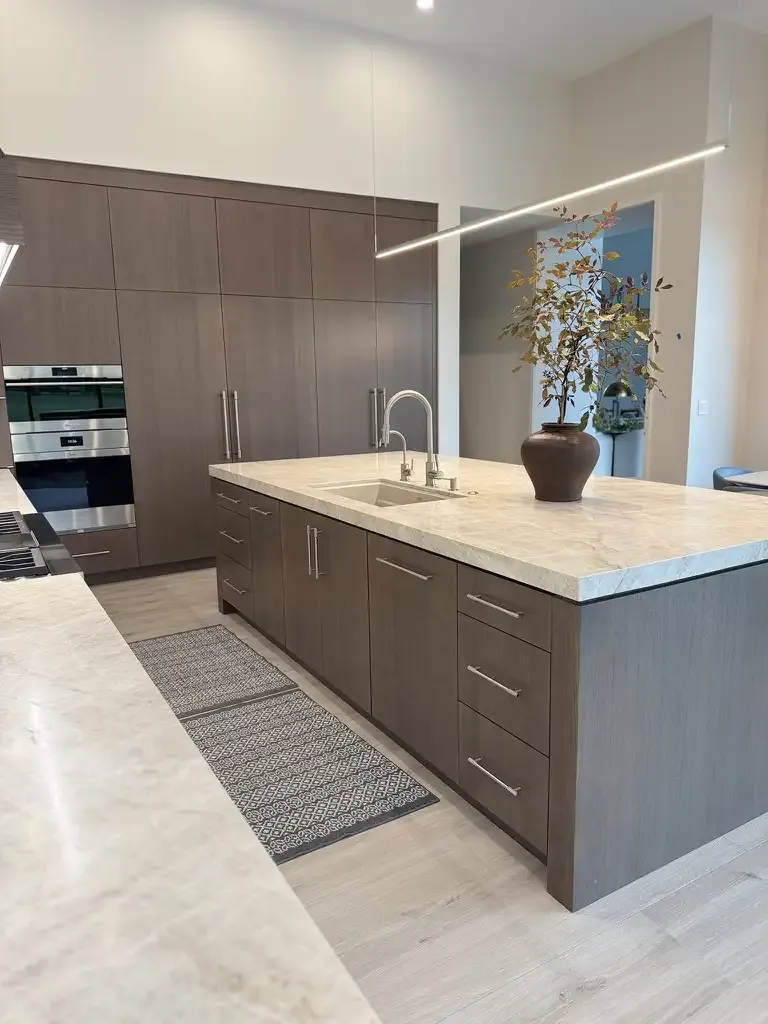 Modern wood island and marble counters by Kitchen & Bath Studios Inc.