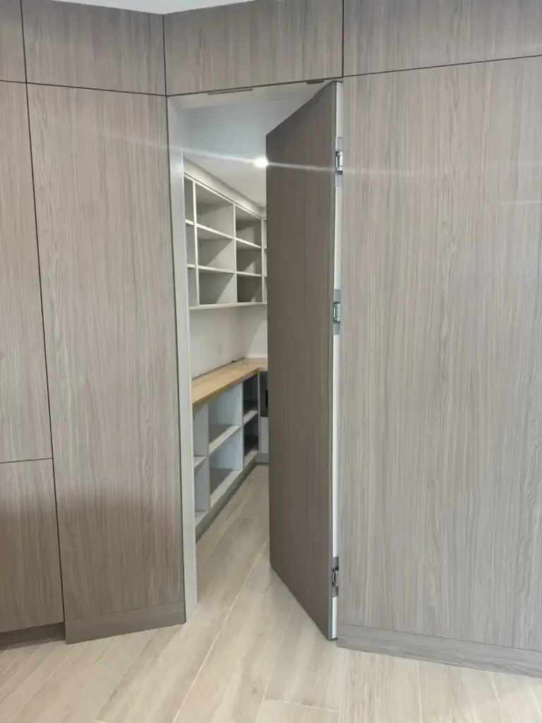 Custom hidden pantry door with wood grain finish by Kitchen & Bath Studios Inc.