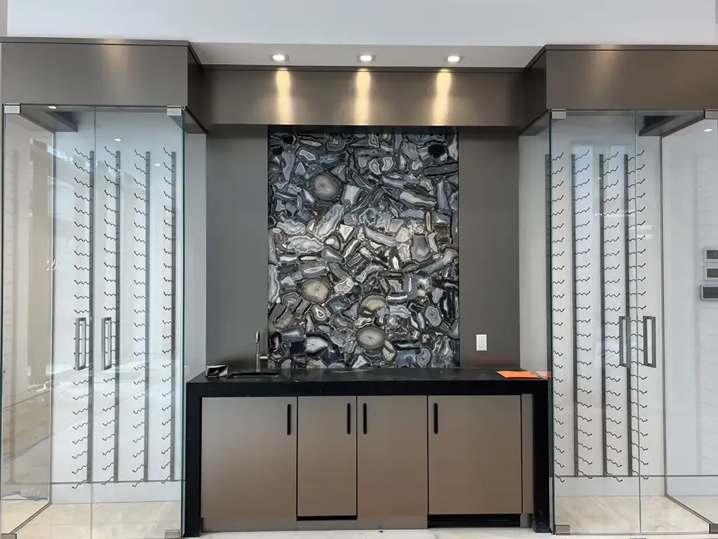 Custom wet bar with backlit agate backsplash by Kitchen & Bath Studios Inc.