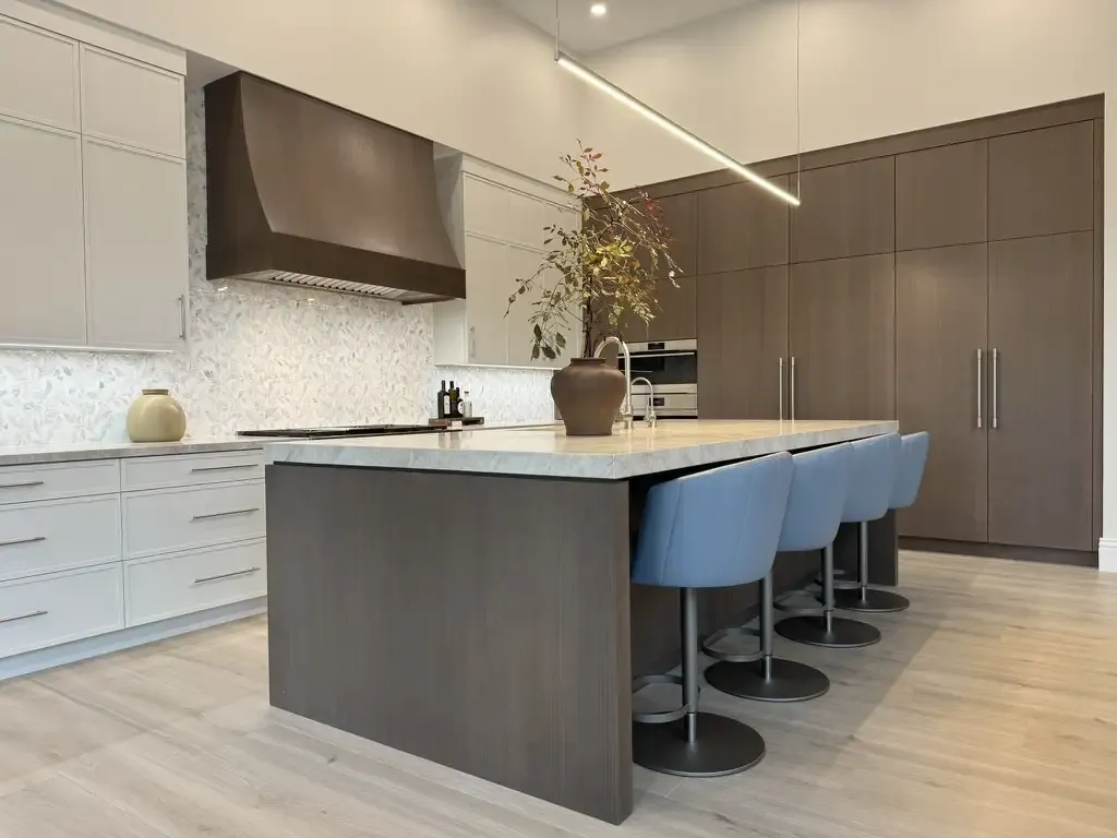 Blue barstools and custom range hood by Kitchen & Bath Studios Inc.