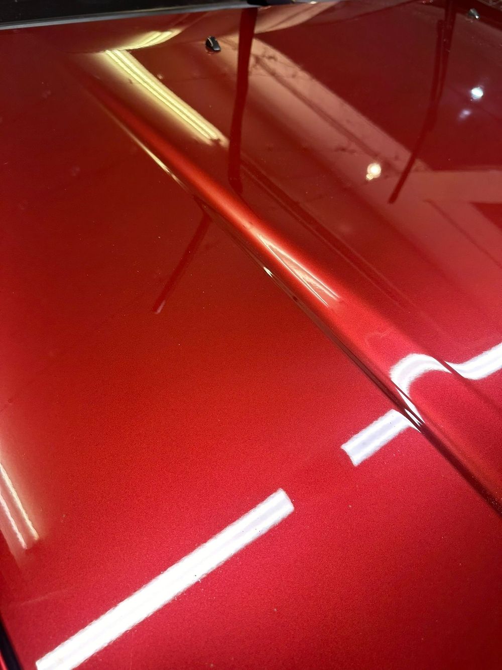 Deep, glossy red paint reflecting light after machine polishing
