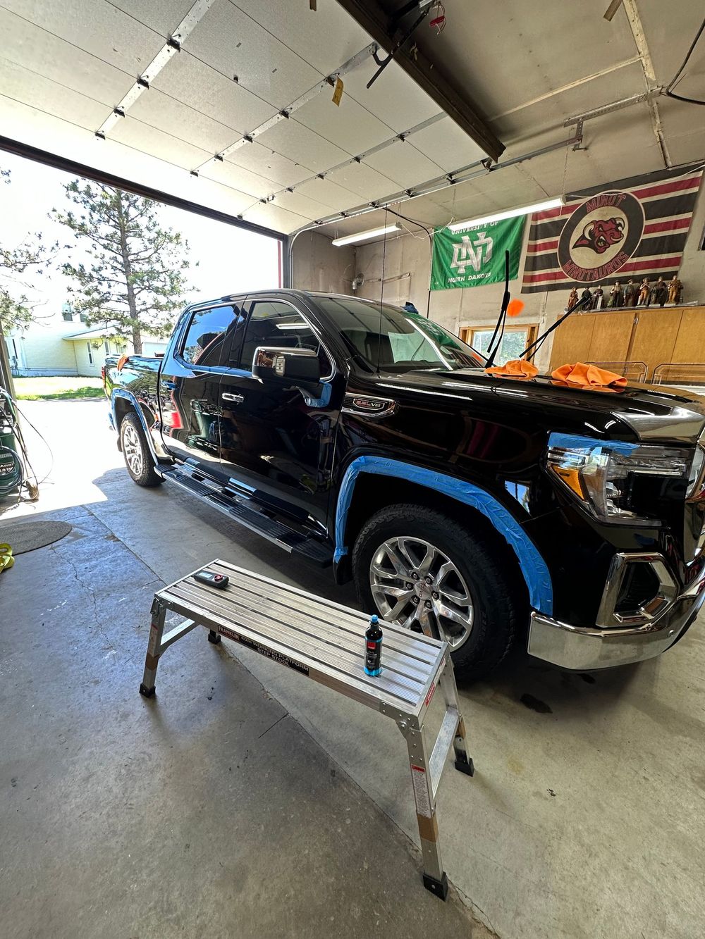 Black GMC truck with its trim masked off for machine polishing in the OG Pro Detail shop