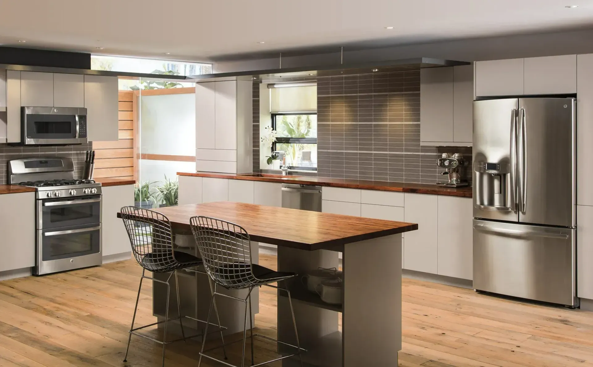 Modern kitchen with stainless steel appliances, large island, and wooden floors