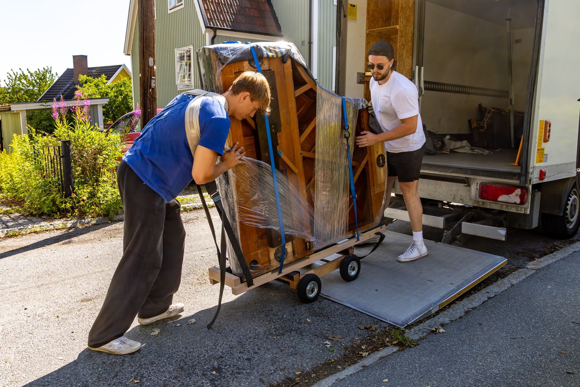 Two movers are loading a piano onto a truck. Two movers are loading a piano onto a truck.