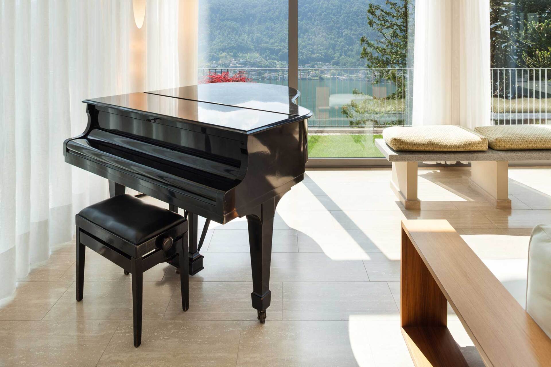 A piano is sitting in a living room next to a window