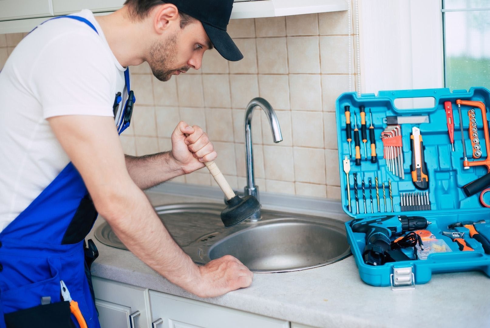 Plumber performing emergency drain cleaning in Orange County kitchen sink