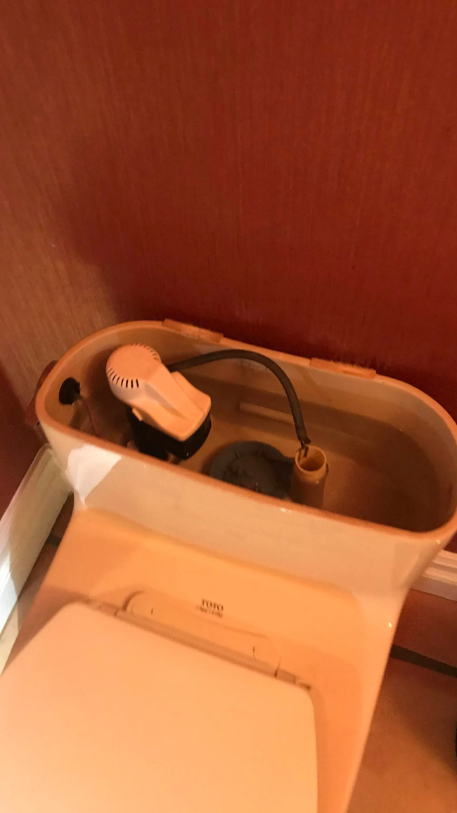 Toilet tank opened for leak detection and plumbing repair service
