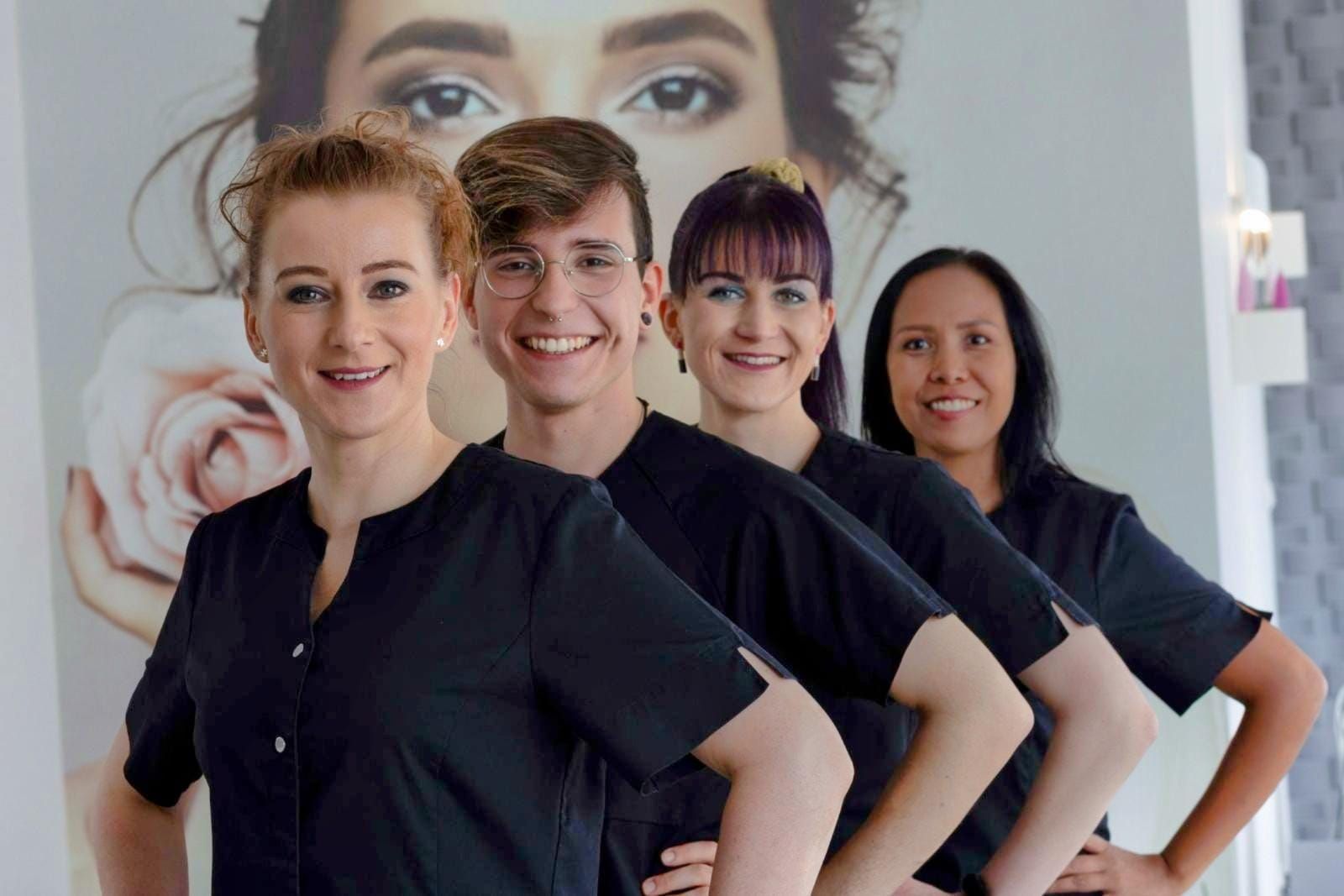 Eine Gruppe von Menschen posiert für ein Foto vor dem Gesicht einer Frau.
