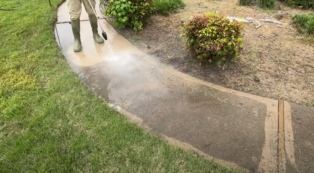 Technician pressure washing a storefront awning.