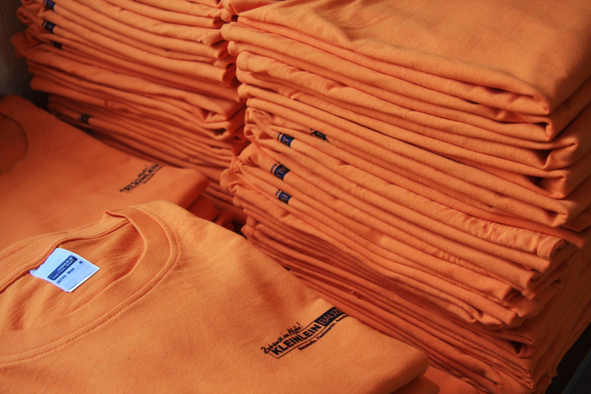 Ein Stapel orangefarbener T-Shirts 