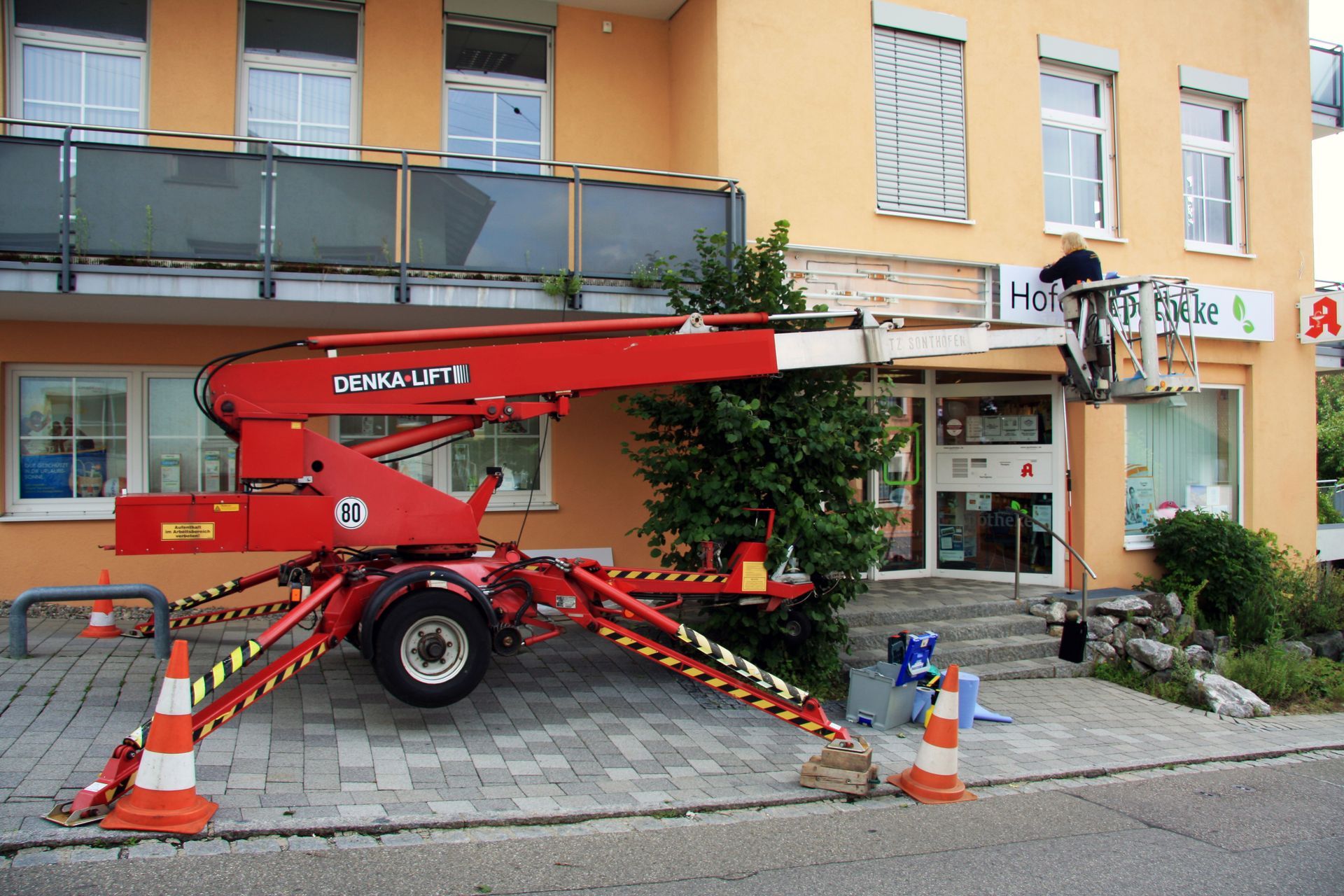 Eine rote Hebebühne steht vor einem Gebäude