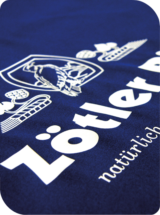 Eine Nahaufnahme eines blauen T-Shirts mit weißer Aufschrift