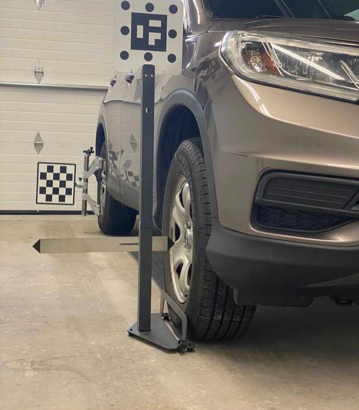Technician positioning calibration target in front of vehicle