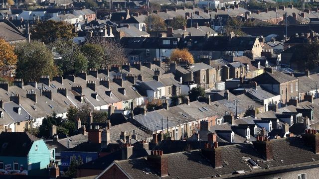 An aerial view of a residential area with lots of houses and chimneys