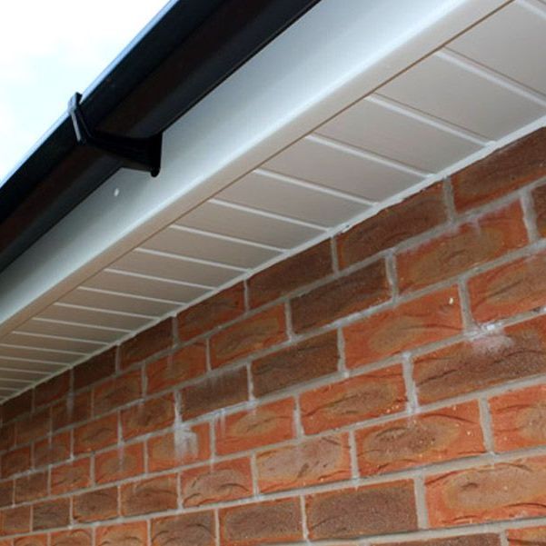 A brick wall with a white gutter on it