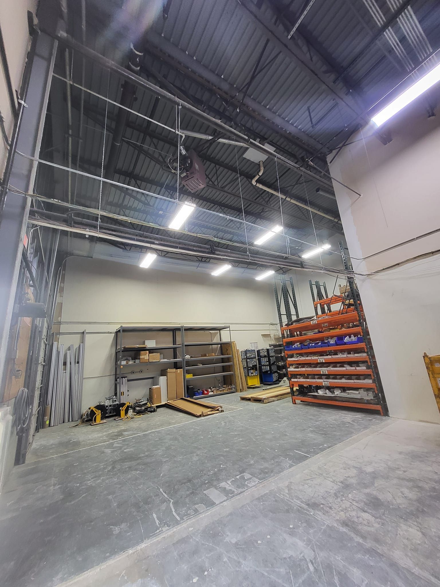 A large warehouse with a lot of shelves and boxes on the floor.