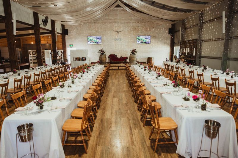 A large room filled with tables and chairs set up for an event at Aberfeldy Barn.