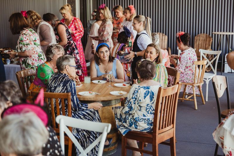 A group of women are sitting around a table at a party held outside at Aberfeldy Barn.