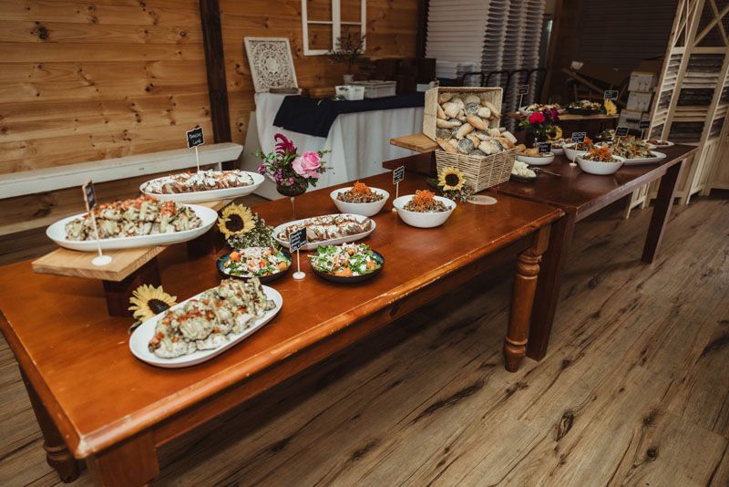 A wooden table topped with plates of food and bowls of food.
